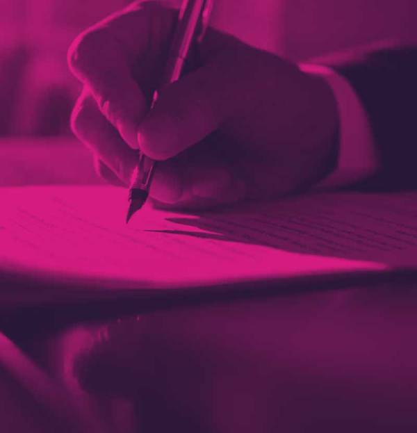 person writing on a paper with pen